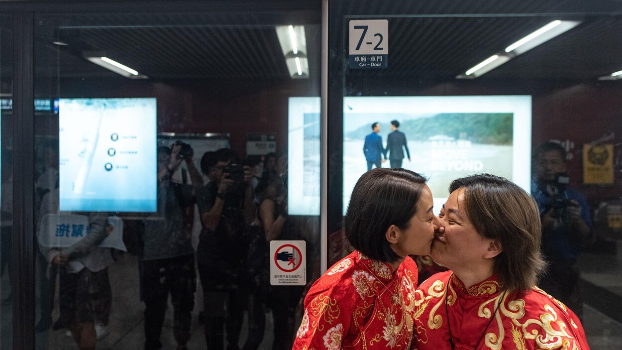 Deux femmes s'embrassent dans une rue de Hong Kong.