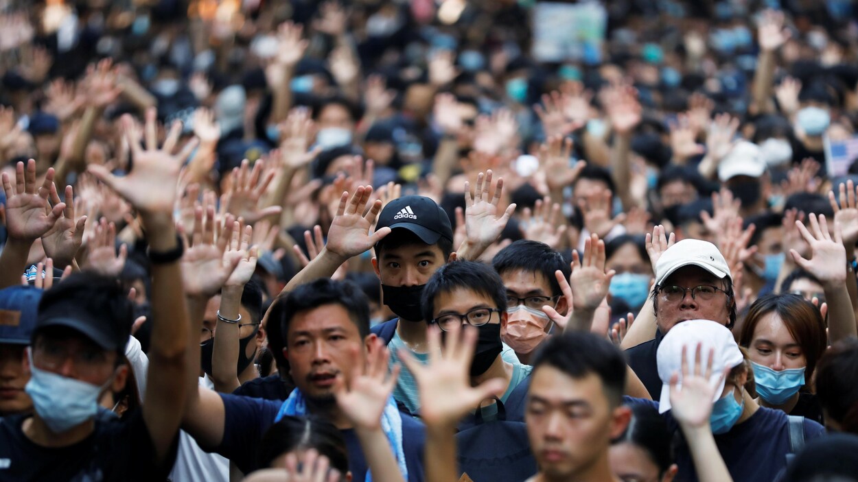 Des gens lèvent les mains en l'air dans une foule.