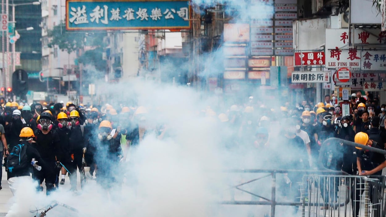 Des manifestants défient les forces de l’ordre qui tentent de les disperser en utilisant des gaz lacrymogènes.