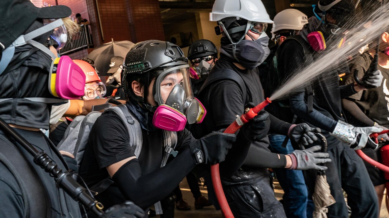 Des manifestants sont masqués et portent des casques.