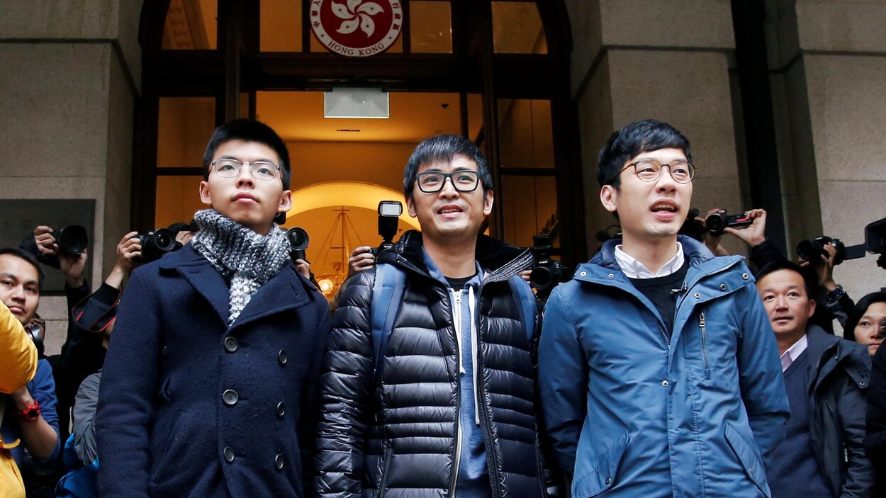Les trois jeunes hommes, fiers et souriants
