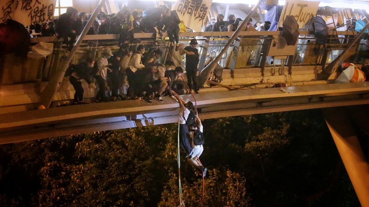Deux tiennent une corde attachée à un pont