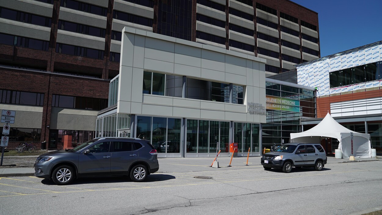 Deux véhicules stationnés devant l'Hôpital de Gatineau.