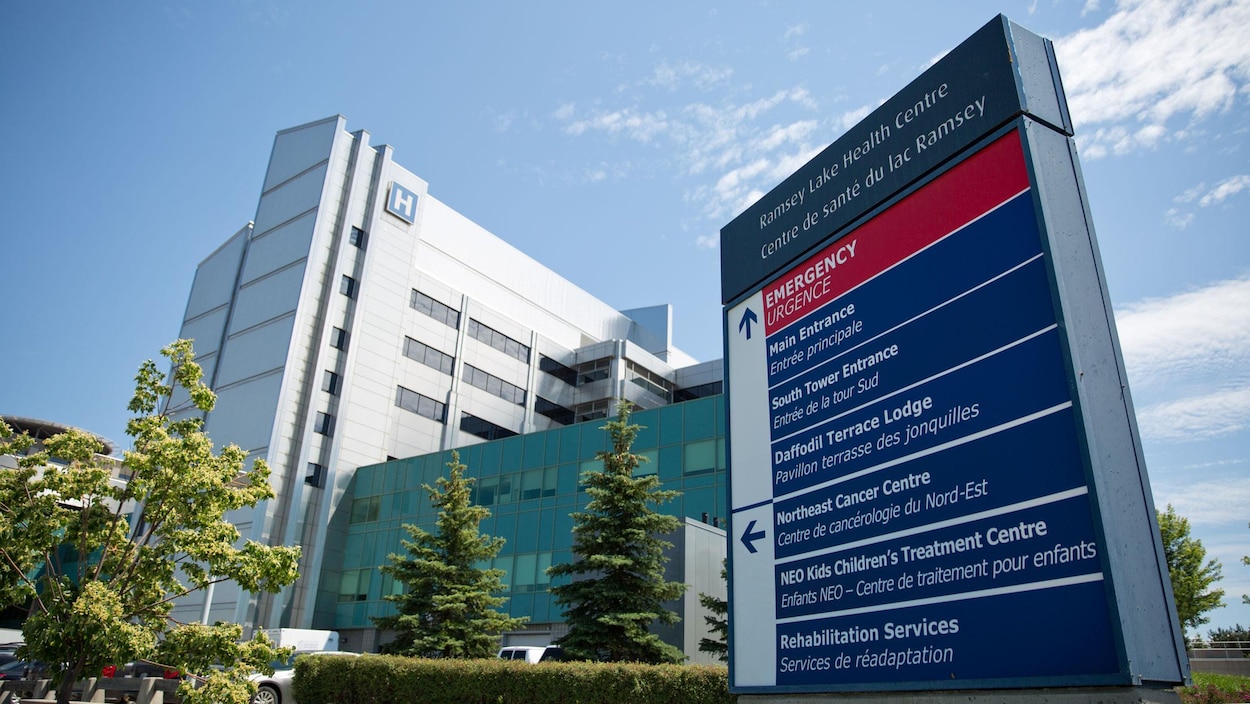 L'hôpital et l'affiche qui présente les différents services L'hôpital et l'affiche qui présente les différents services