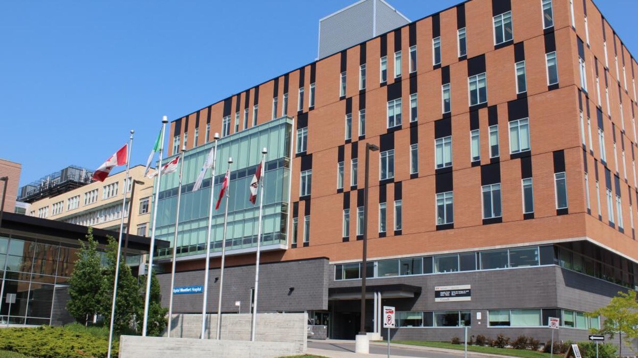 La façade de l'hôpital Montfort devant lequel se trouve des drapeaux.