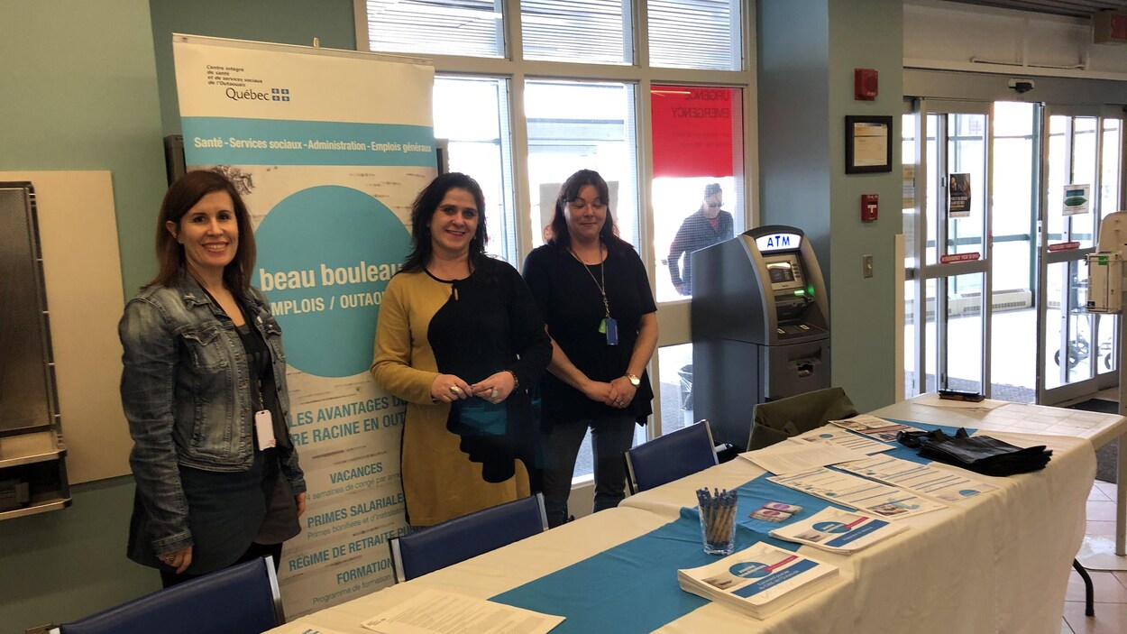 Trois femmes posent derrière une table à l'entrée de l'Hôpital du Pontiac à Shawville