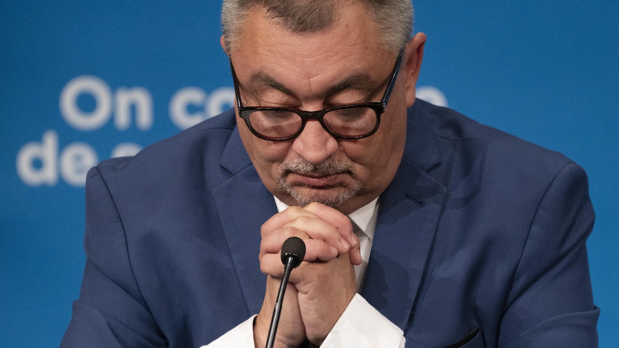 Le directeur de la santé publique du Québec, Horacio Arruda, les mains jointes et la tête baissée.