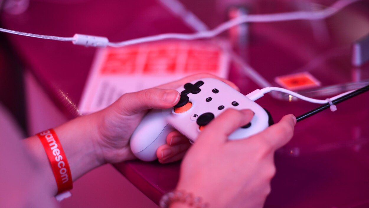 Des mains tiennent une manette de jeu vidéo.