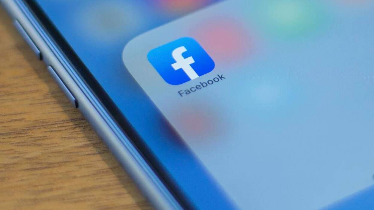 Le logo de Facebook s'affiche sur l'écran d'un téléphone.