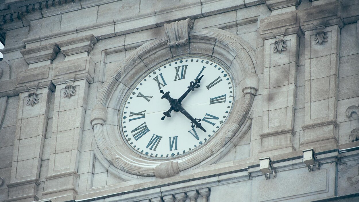 Zoom sur l'horloge de l'Hôtel de ville de Montréal qui indique 13 h 20 par une froide journée d'hiver. Zoom sur l'horloge de l'Hôtel de ville de Montréal qui indique 13 h 20 par une froide journée d'hiver.