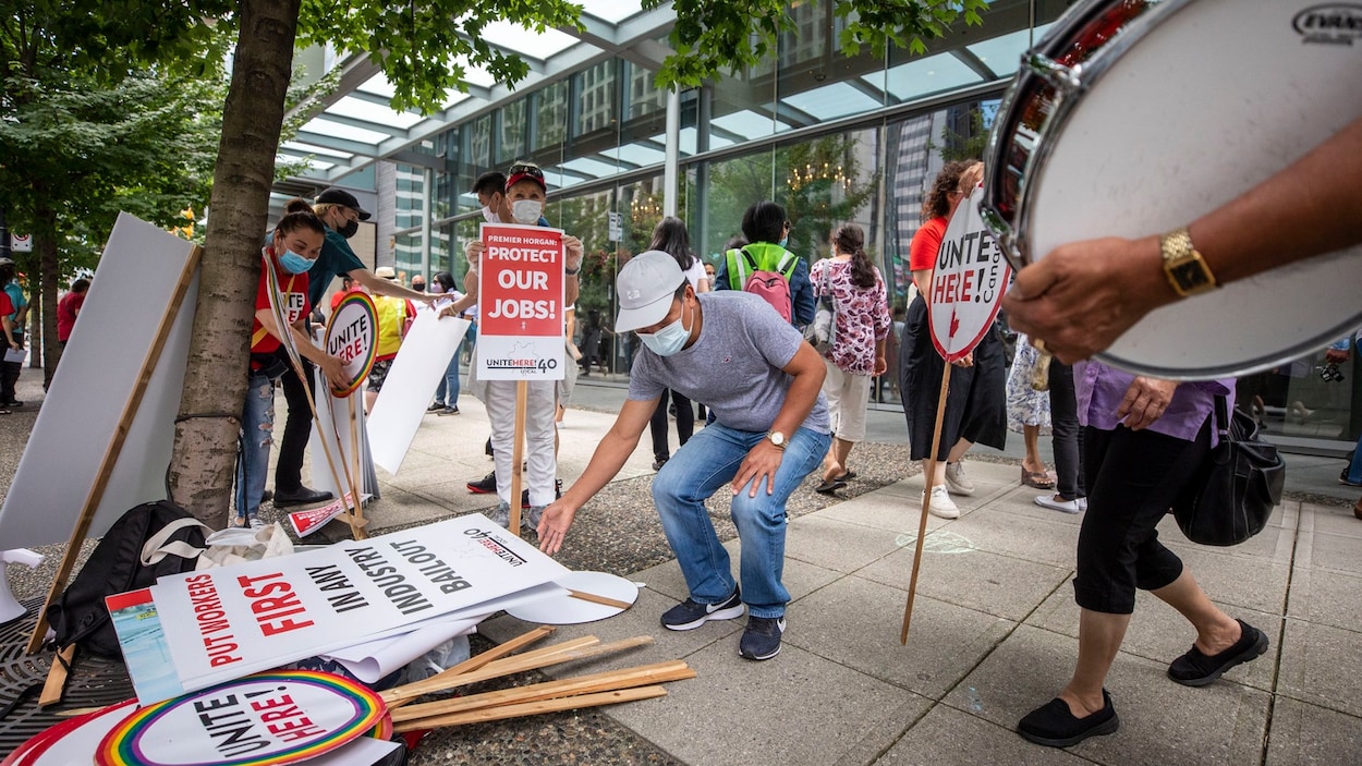Des manifestants ramassent des pancartes.