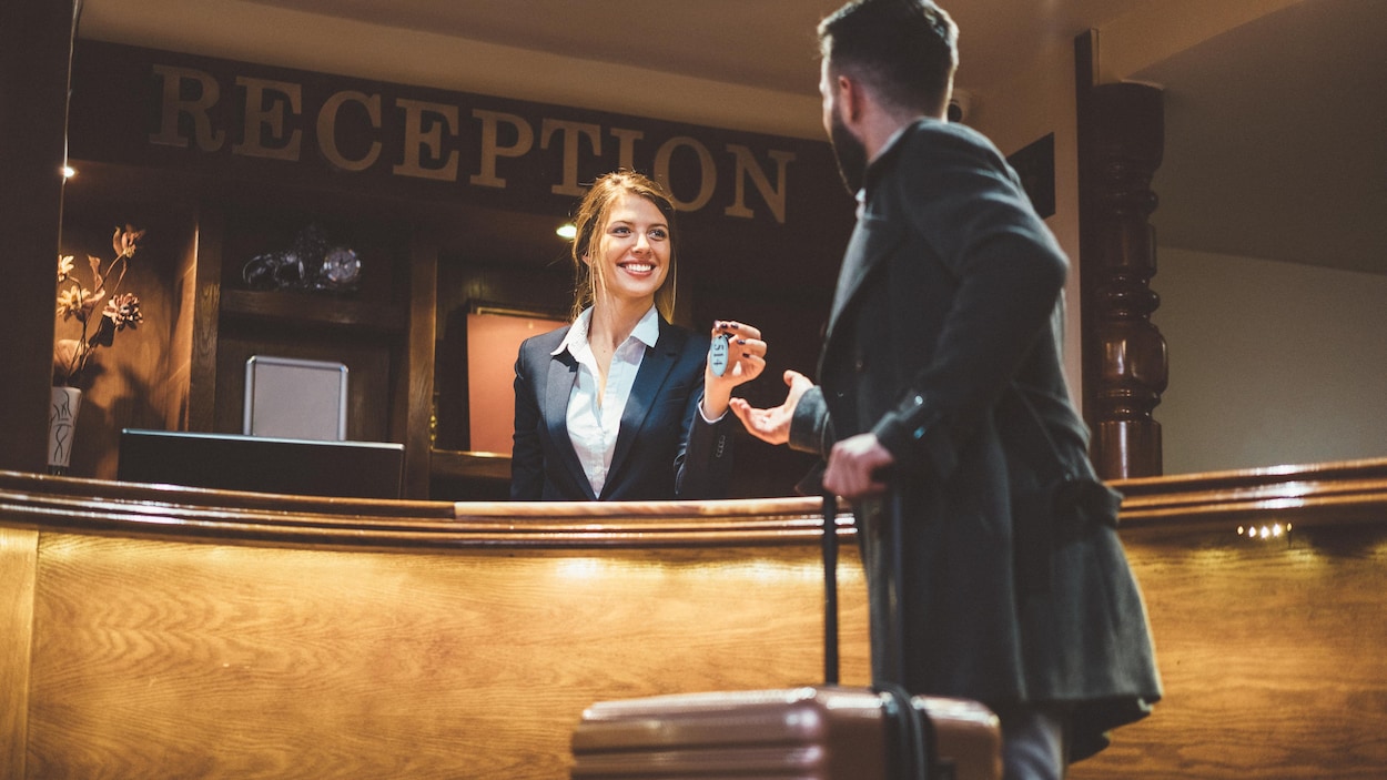 Un homme s'enregistre à l'accueil d'un hôtel.