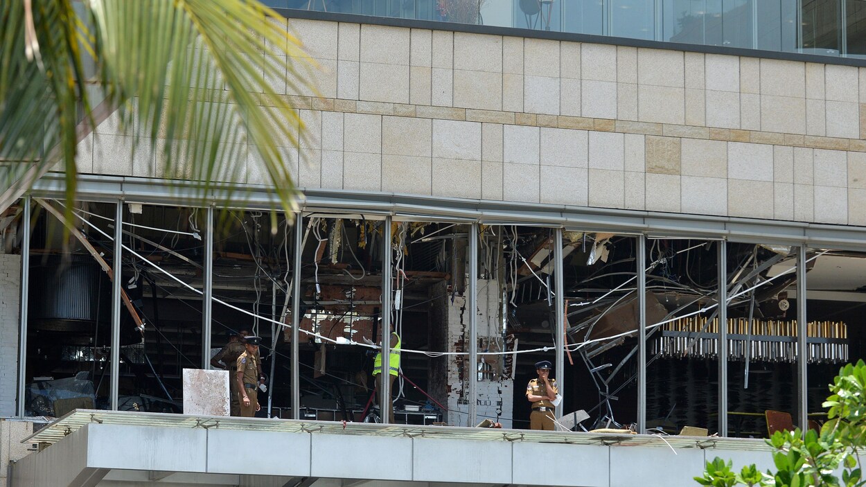 Des policiers se tiennent devant l'hôtel Shangri-La, dont les vitres ont toutes été détruites par l'impact de l'explosion.