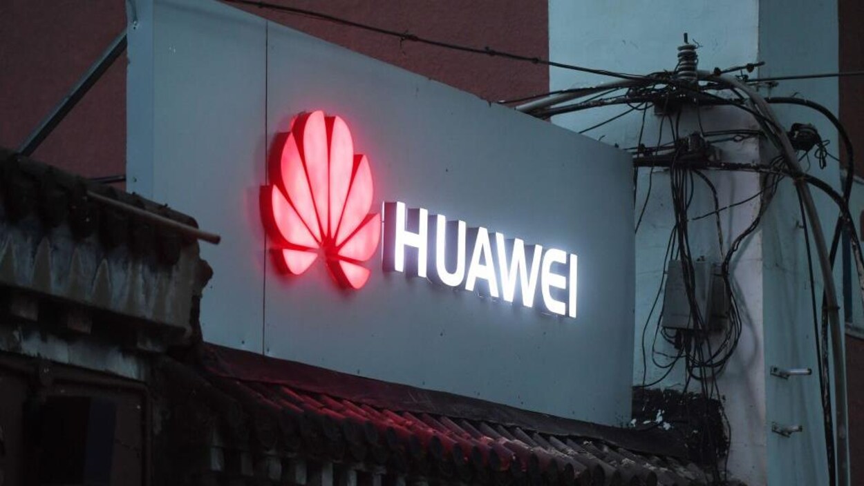 Une enseigne lumineuse porte le logo du fabricant chinois Huawei au-dessus d'un commerce qui vend des téléphones intelligents à Pékin, en Chine.