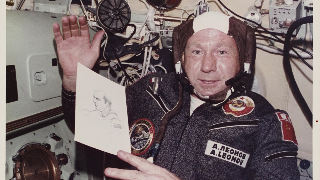 Alexei Leonov tient un portrait d'un collègue pendant une mission spatiale.
