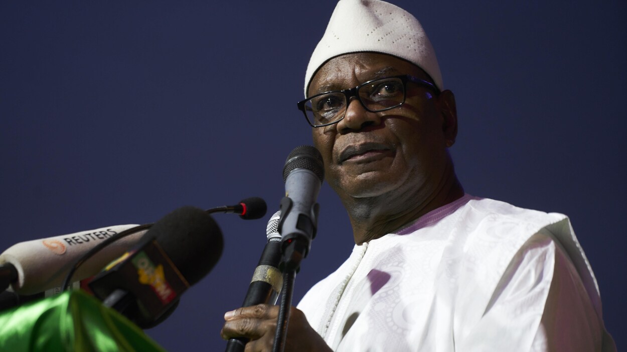 Ibrahim Boubacar Keïta porte une tunique blanche et parle dans un micro.