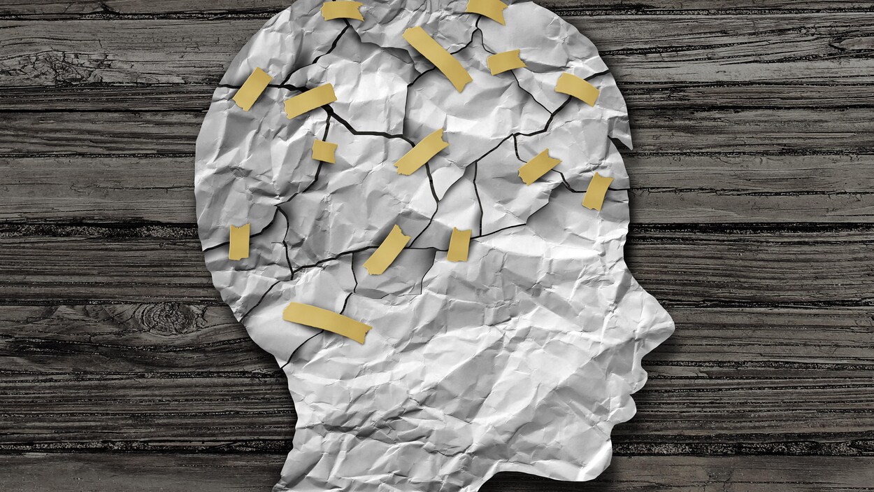 Une tête d'enfant illustrée en papier avec les éléments du cerveau reliés par des rubans gommés Une tête d'enfant illustrée en papier avec les éléments du cerveau reliés par des rubans gommés