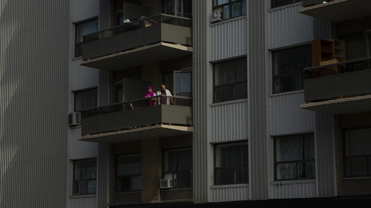 Un couple à son balcon.