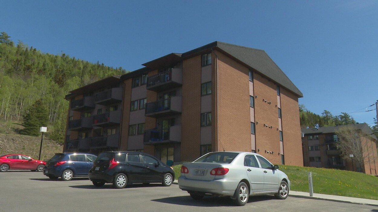 Des voitures sont stationnées devant un immeuble à logements de Gaspé.