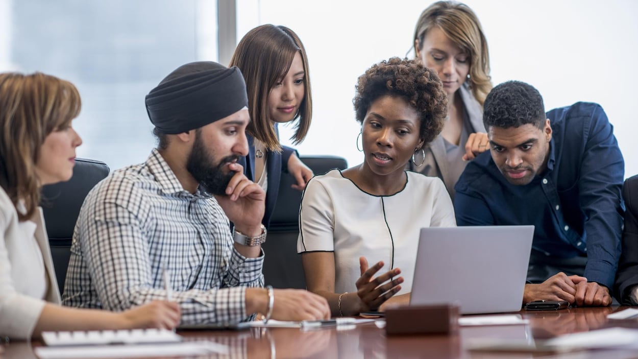Des employés issus de la diversité sont assis autour d'une table.