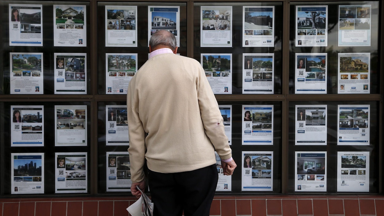 Une personne de dos regarde des maisons à vendre. Une personne de dos regarde des maisons à vendre.