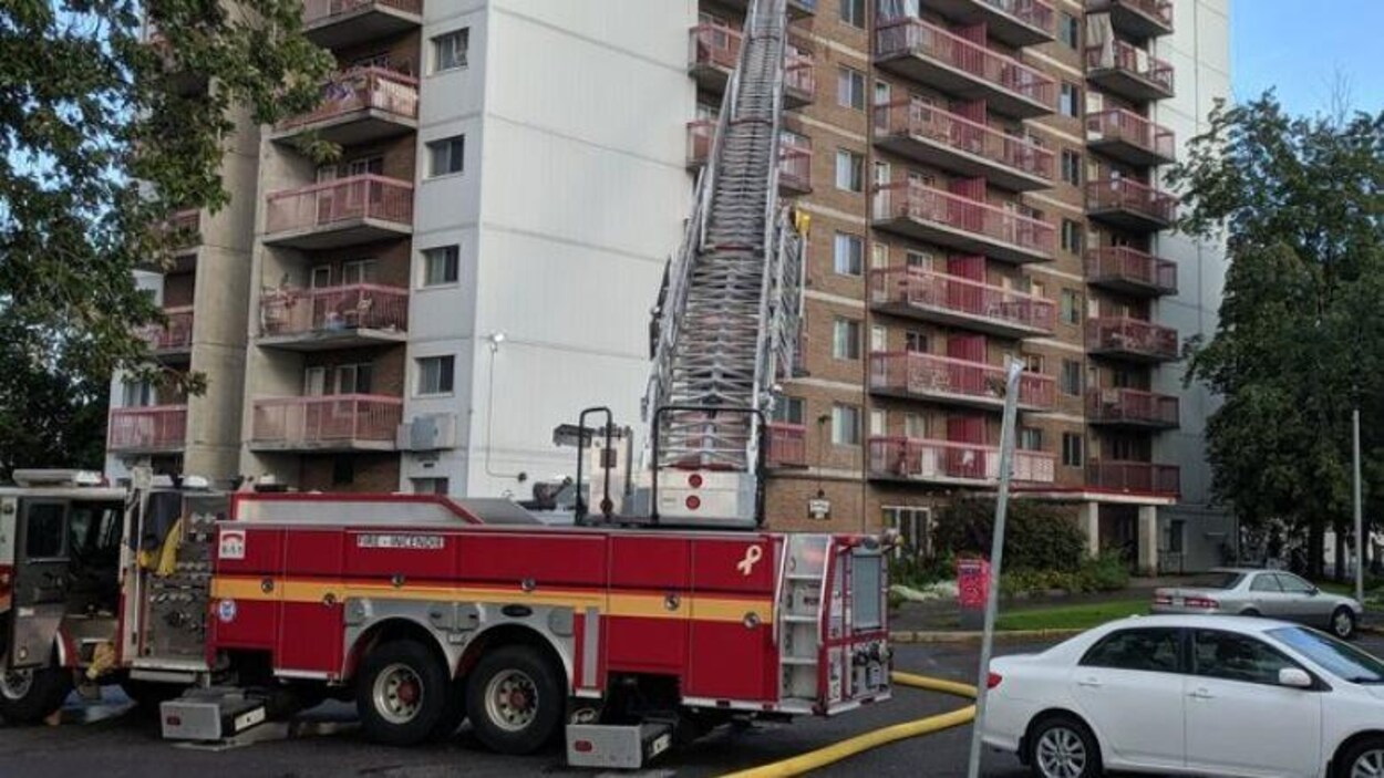 Un camion d'incendie devant un immeuble.