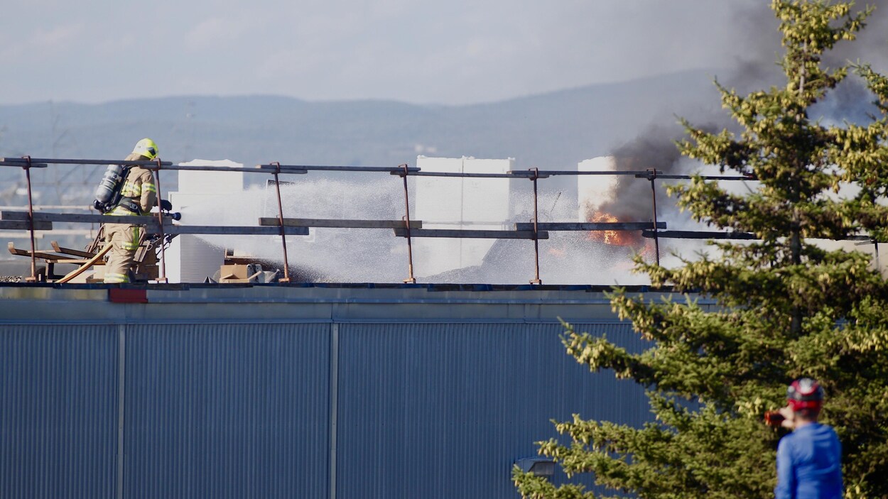 Des pompiers combattent un incendie sur le toit d'un immeuble commercial à Québec