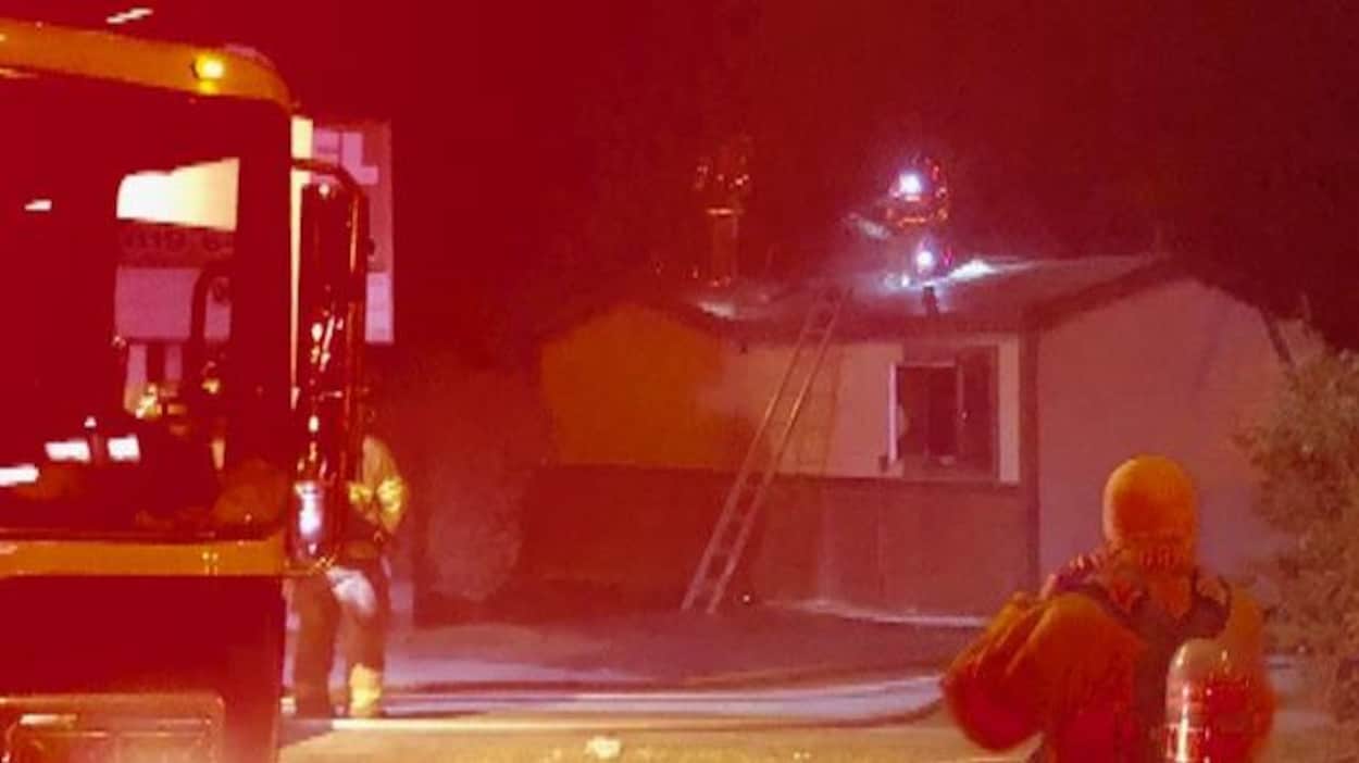 Des pompiers sur les lieux d'un incendie de nuit. Des pompiers sur les lieux d'un incendie de nuit.