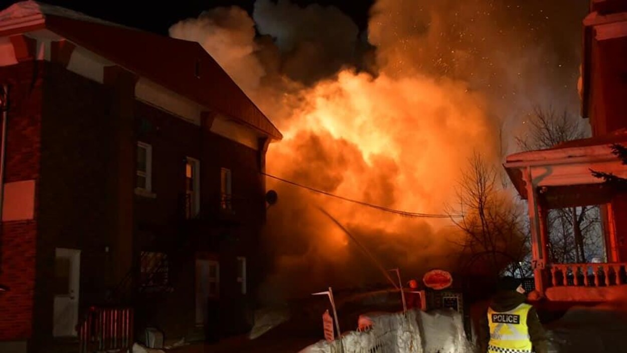 Un épais nuage de fumée mêlé de flammes se dégage d'un bâtiment.
