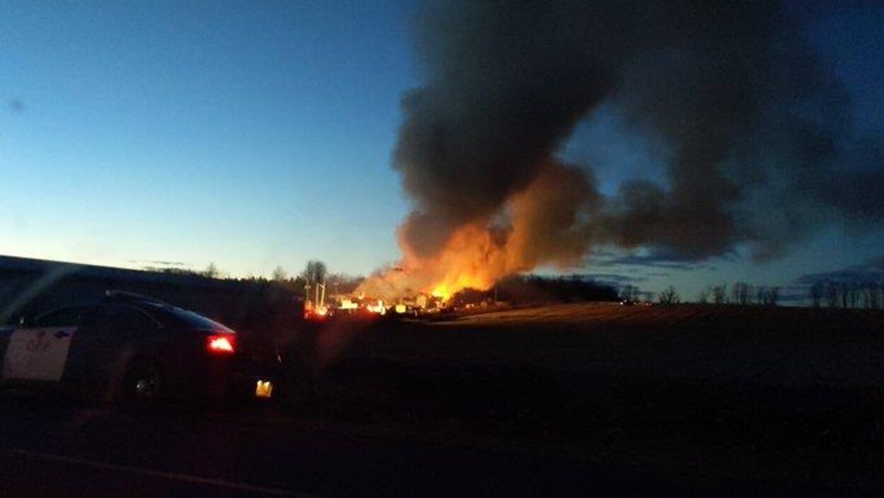 Un incendie et un immense nuage de fumée vus d'une route dans l'est ontarien.