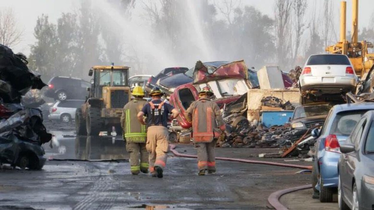 Des pompiers entourés de carcasses de voitures