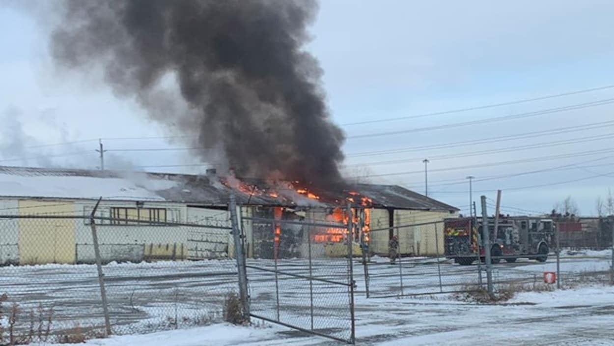 De la fumée noire qui s’échappe d’un bâtiment en flamme.