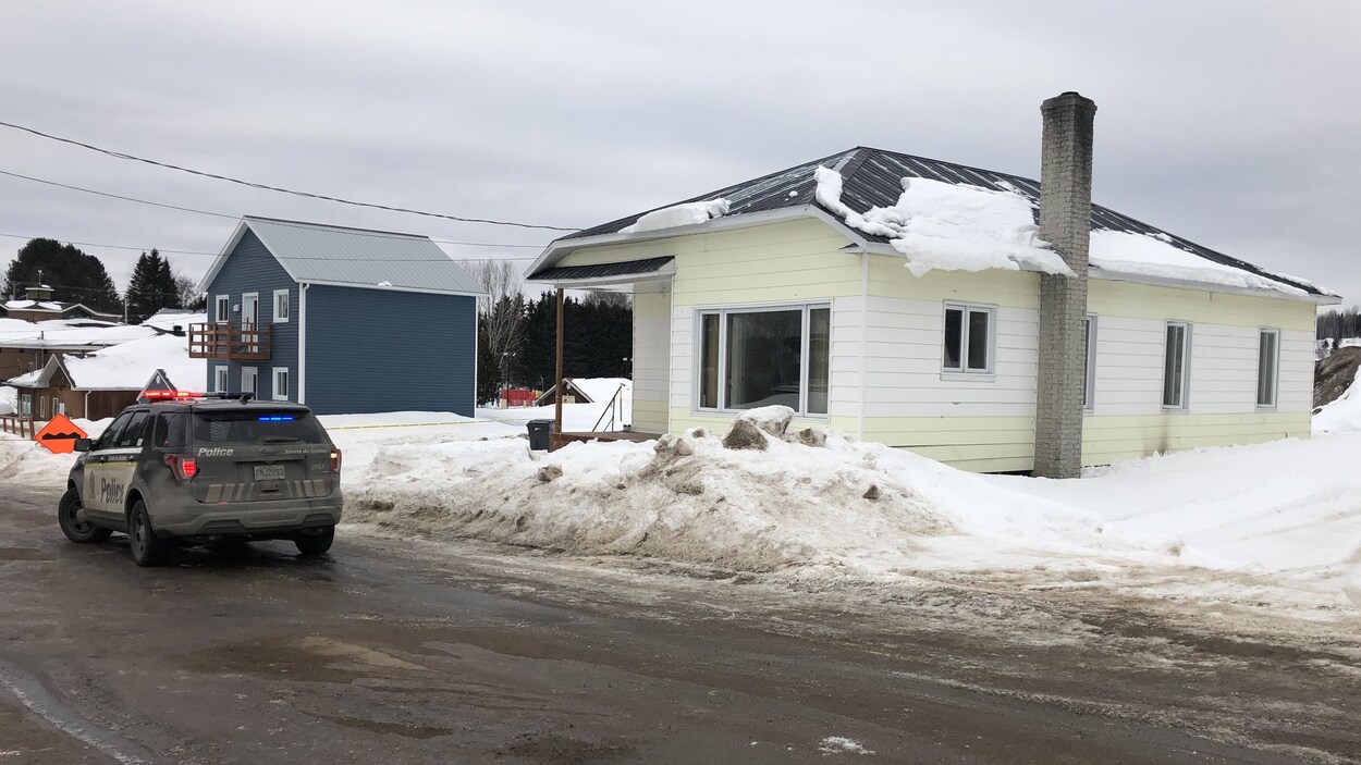 Une voiture de la SQ devant la maison touchée par le feu.
