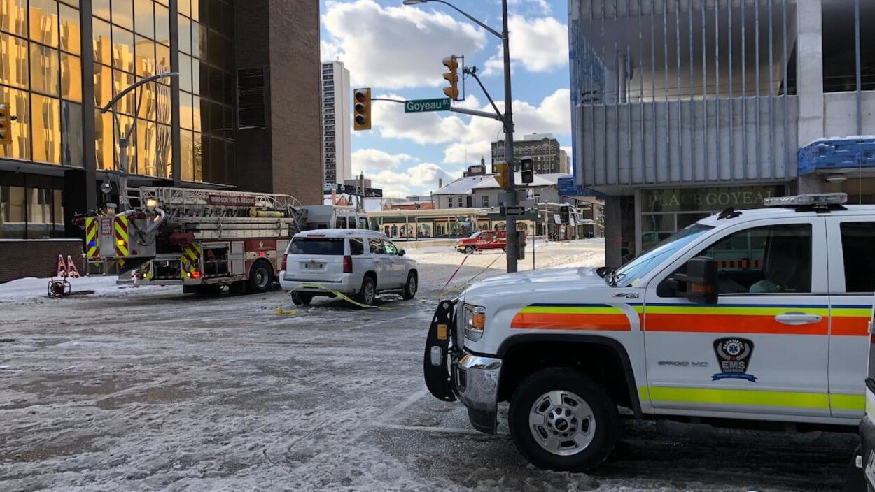 Un camion de pompiers et une ambulance sont sur scène d'intervention lors d'un incendie en ville. Il y a de la neige au sol