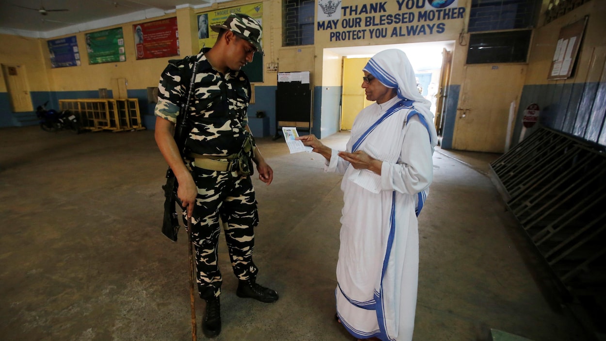 Un soldat vérifie les papiers d'identité d'une religieuse.