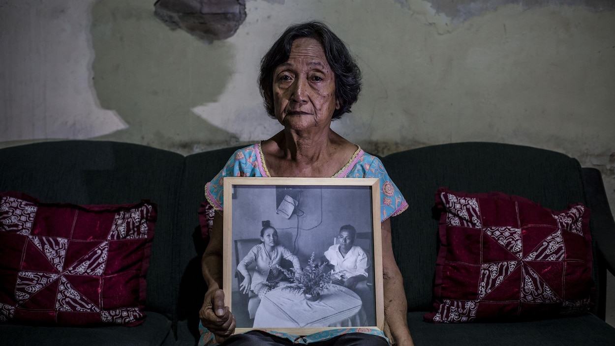 Une Indonésienne tient un portrait de ses parents entre ses mains. Une Indonésienne tient un portrait de ses parents entre ses mains.