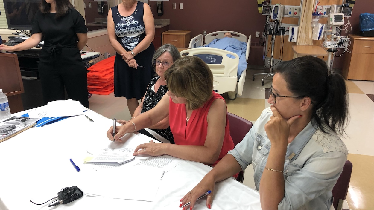 Un groupe de femmes assises autour d'une table dans une clinique.