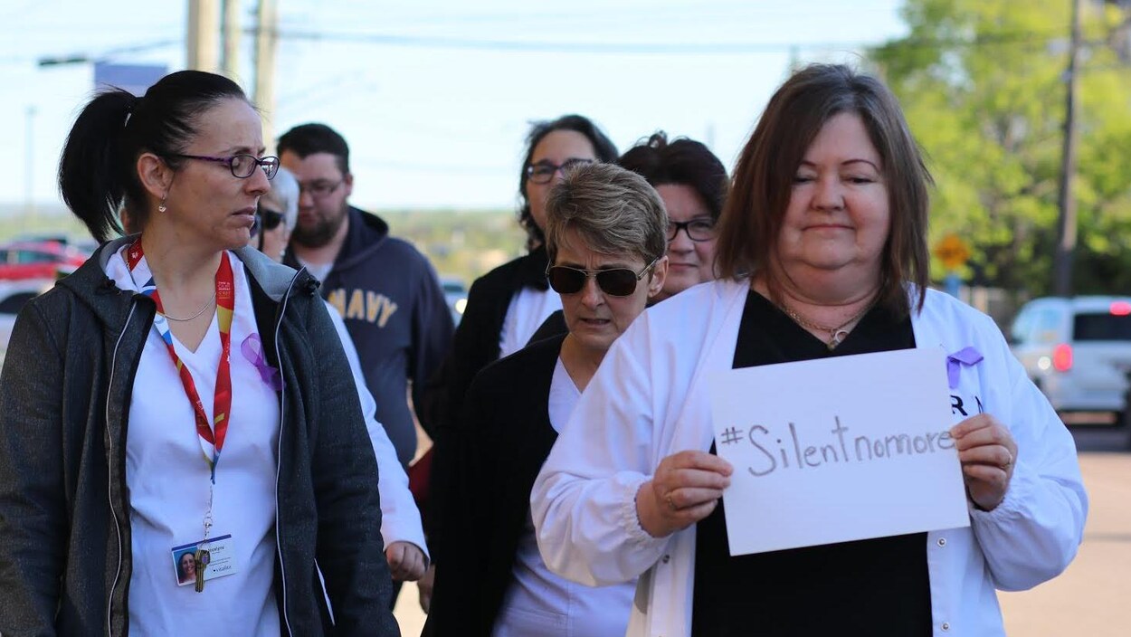 Des infirmières marchent dans les rues de Moncton, la mine sombre.