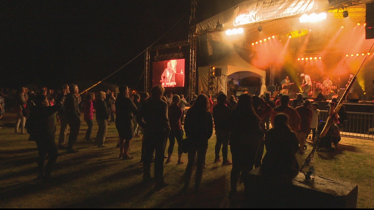 Un public debout assiste à un spectacle