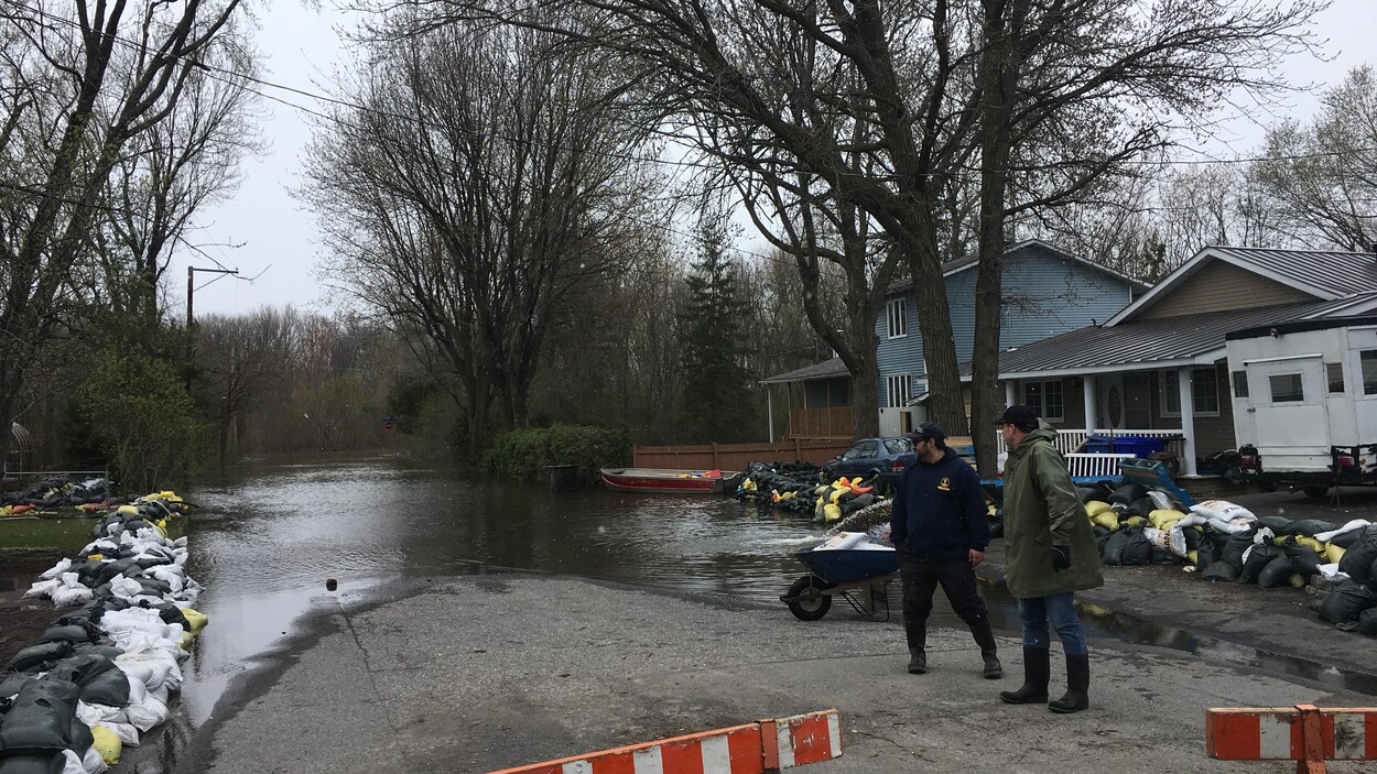 Des digues de sacs de sable pour stopper les inondations de chaque côté de la rue, bloquée par des barricades.