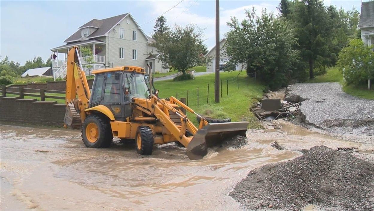 Un tracteur au milieu de l'eau dans une rue inondée Un tracteur au milieu de l'eau dans une rue inondée