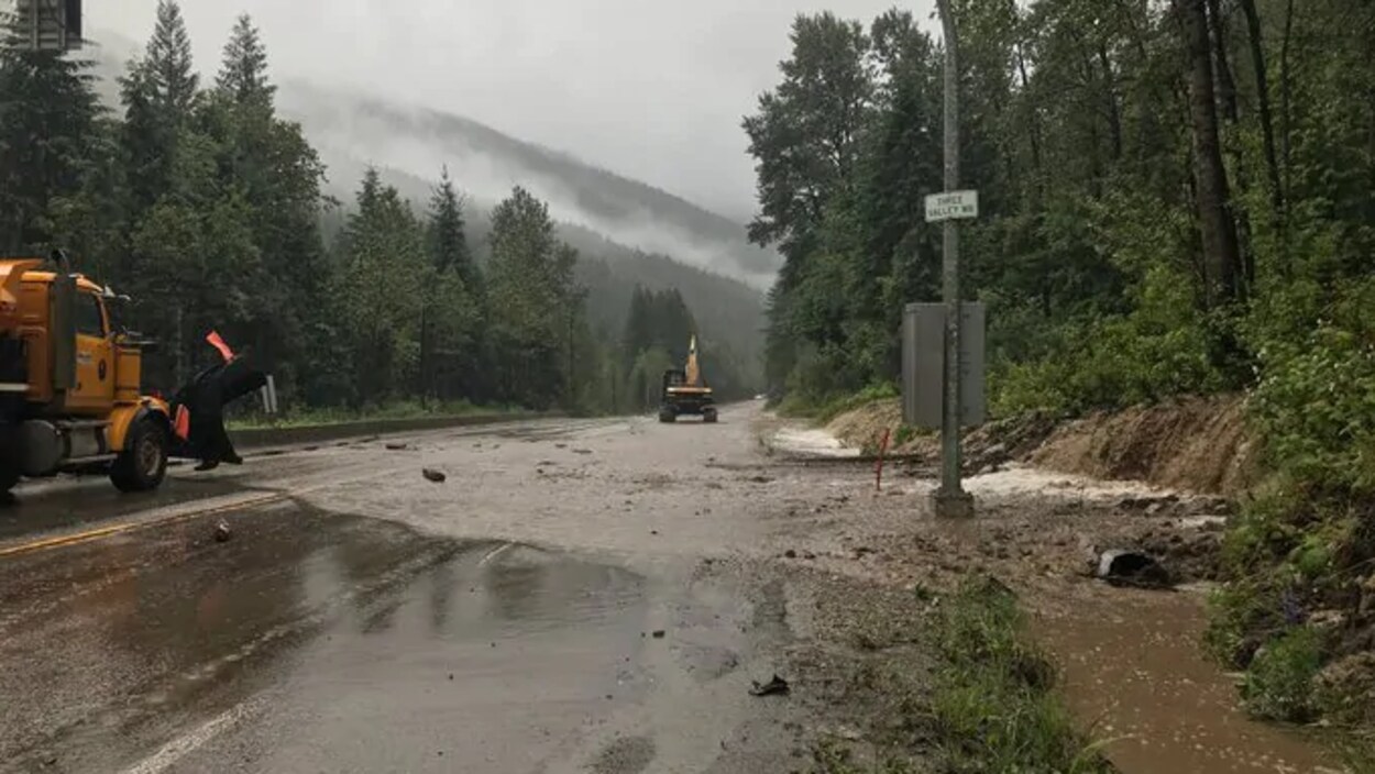 Une route inondée avec de la machinerie lourde.