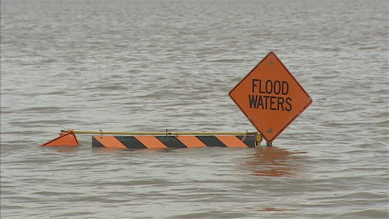 Un panneau qui indique "Flood Waters", planté dans l'eau.