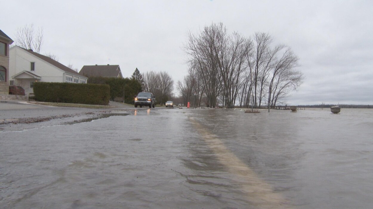 La rivière est sortie de son lit et recouvre la moitié d'une rue.
