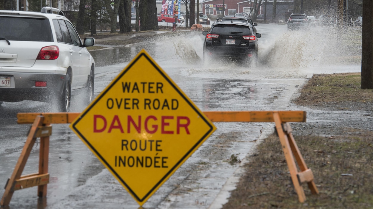 Panneau routier avertissant qu'une route est partiellement inondé.