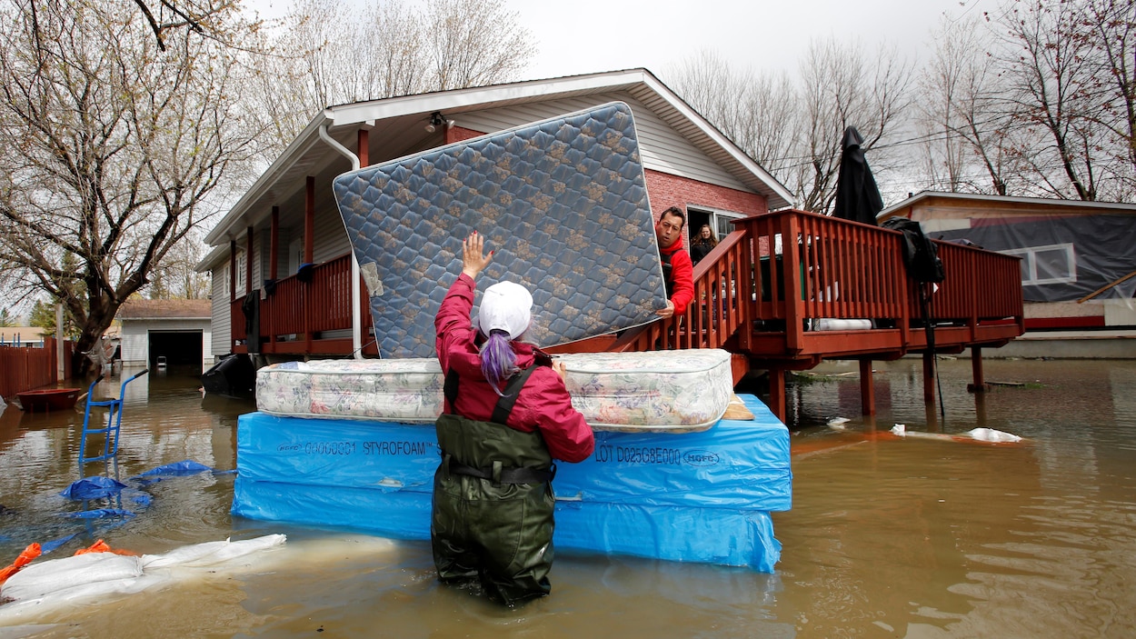 Jean-François Perrault et Julie Theriault déplacent des matelas d'une résidence inondée d'une maison de Gatineau.