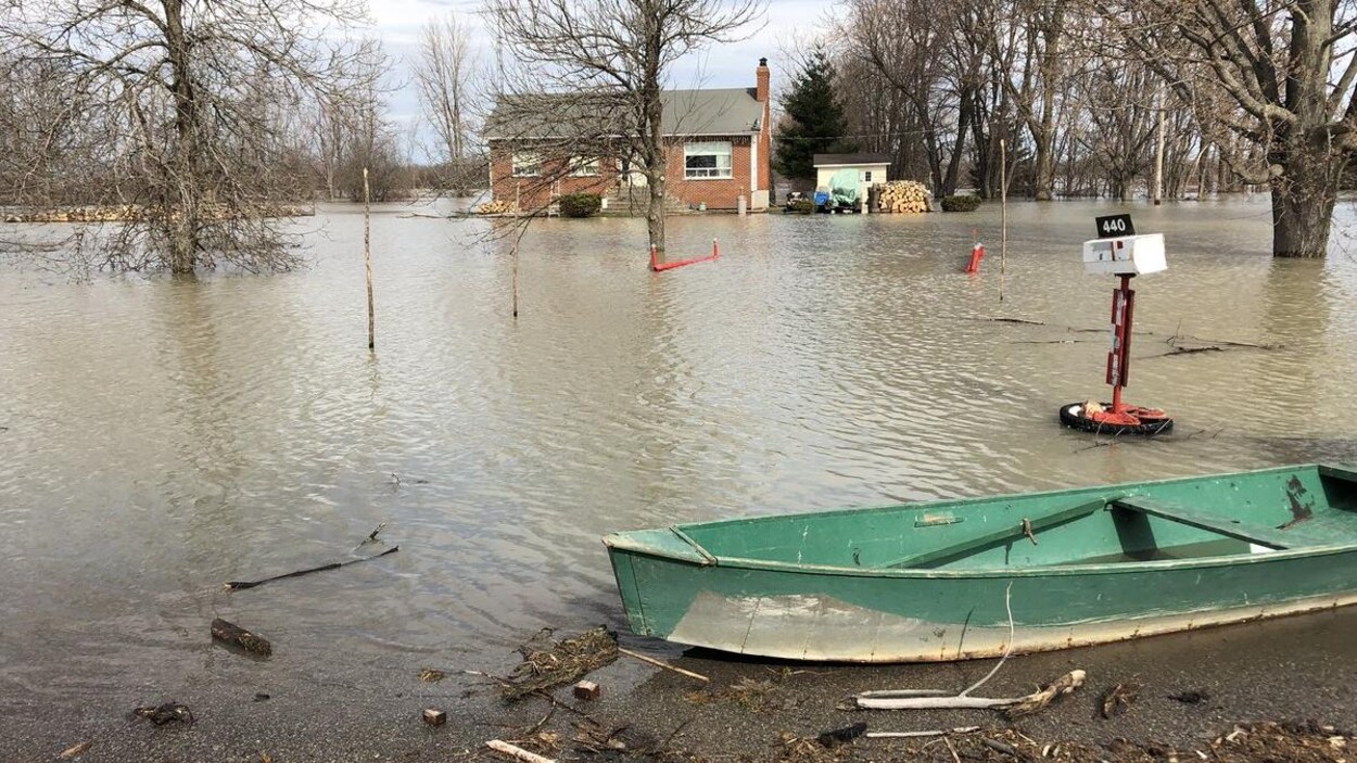 Une chaloupe se trouve devant une maison inondée de Maskinongé.