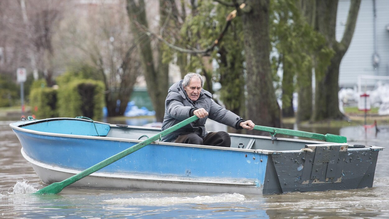 Un homme rame dans une barque.