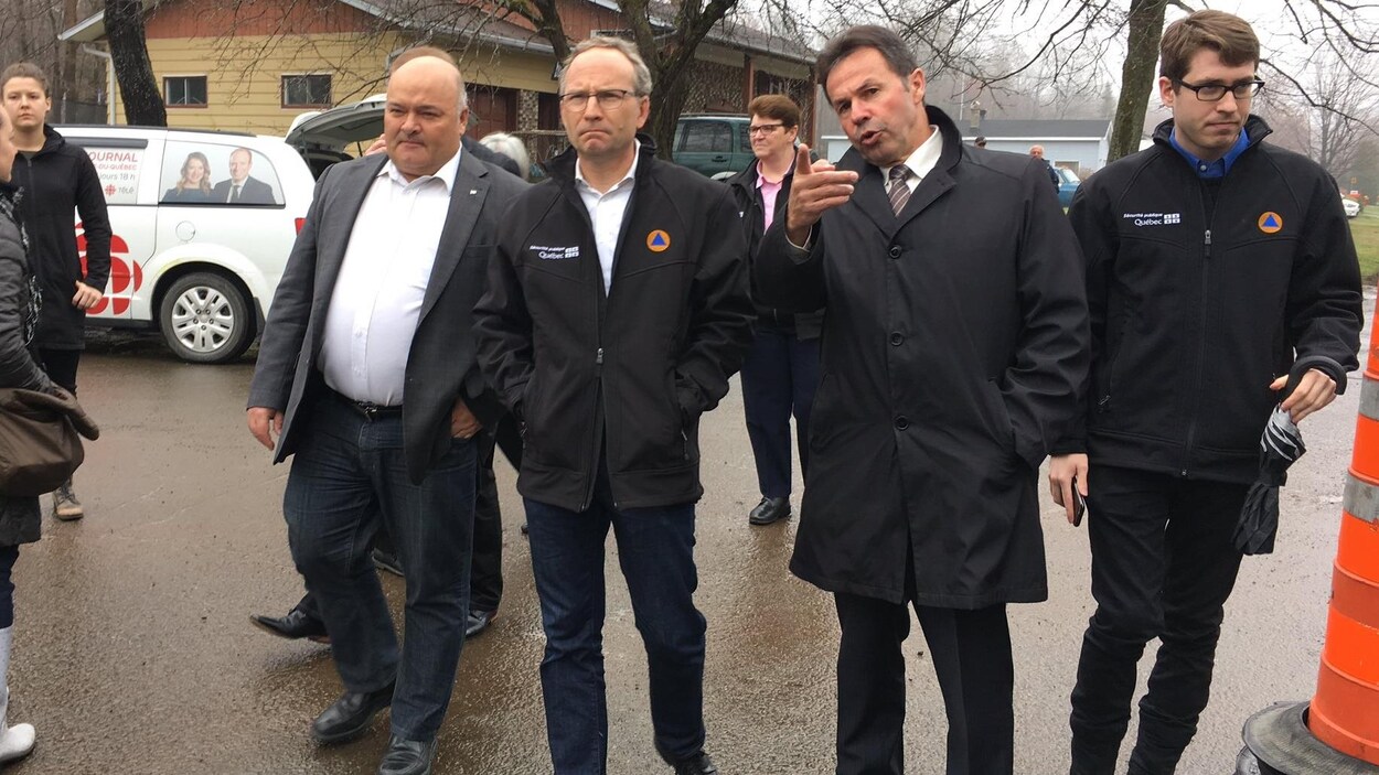 Le ministre de la Sécurité publique, M. Martin Coiteux, en compagnie du maire de Shawinigan, Michel Angers, et du député Pierre Giguère lors du point de presse au sujet des inondations.