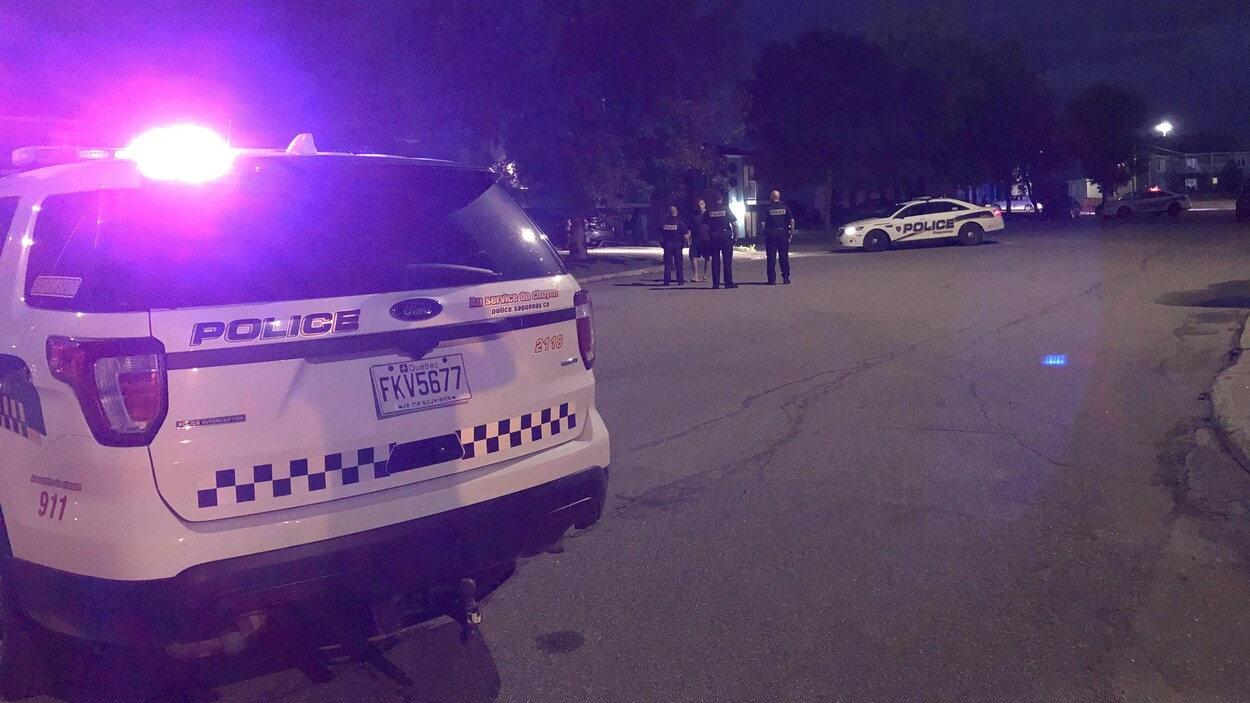 Des voitures de police et plusieurs agents en train de discuter.